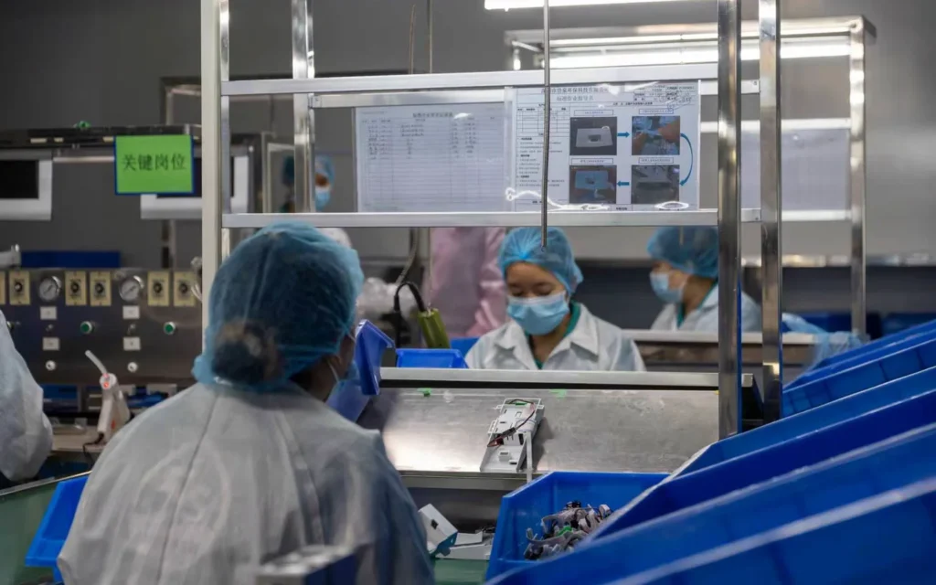Workers assembling and inspecting components at a production workstation